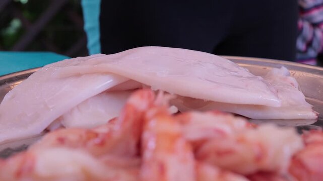 Scallops without shells, shrimp and squid on a plate, cooking seafood