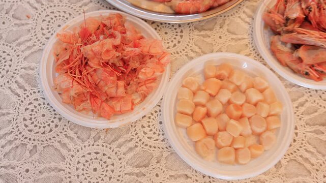 Scallops without shells, shrimp and squid on a plate, cooking seafood