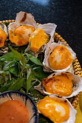 Nha Trang, Vietnam. Oyster grilled in cheese being served at local restaurant.