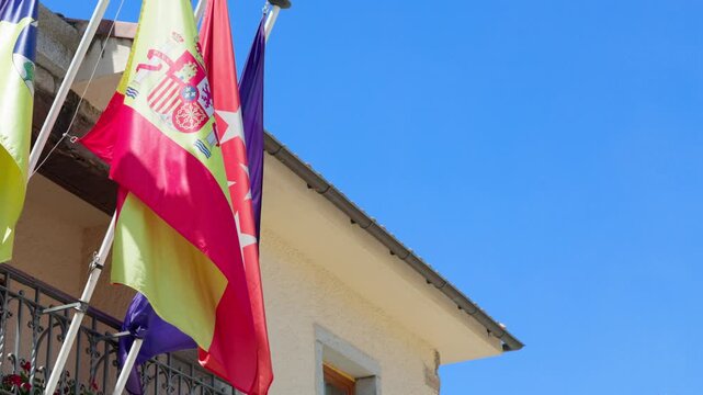 Flags fluttering in a blue sky. The flags are from Europe, Spain, Madrid and Torrelodones. Copy space
