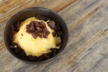 Delicious Creamy Omelet with Savory Meat Topping in Rustic Bowl