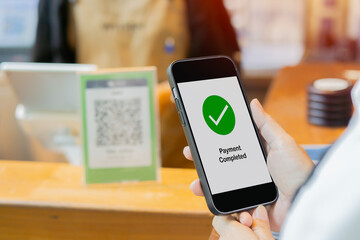 Customer scanning QR code, making a quick and easy contactless payment with her smartphone