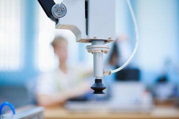 Close-up of robotic arm with suction end effector in modern STEM classroom, ready for precise automation tasks and hands-on education, Industrial automation concept.