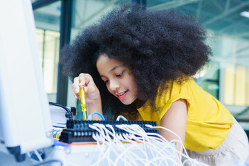 African American girl assembling electronic components in STEM lab, showcasing hands-on learning,...