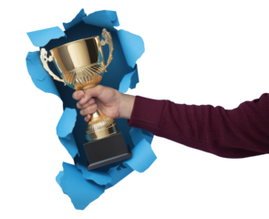 hand holding gold trophy through blue torn paper.