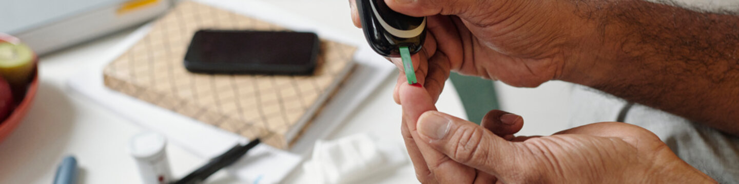 Person checking blood sugar level with glucose meter indoors