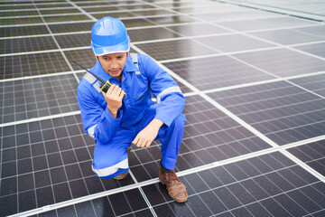 Electrical engineer inspecting and installing a solar panels on the building rooftop.