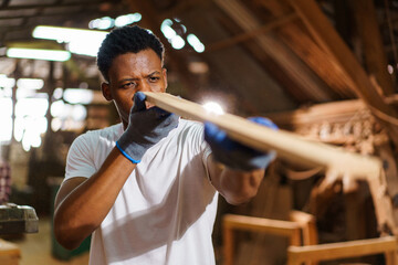 Professional African male carpenter is working professionally in sawmill - workshop.