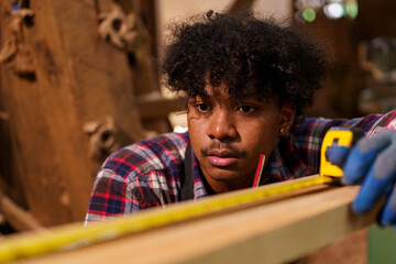 Professional African male carpenter is working professionally in sawmill - workshop.