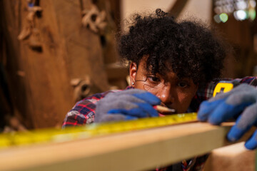 Professional African male carpenter is working professionally in sawmill - workshop.