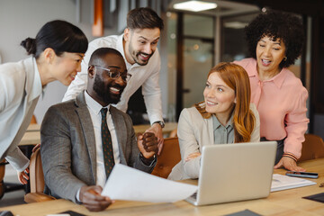 Business team collaborating at office meeting with laptop and documents