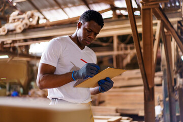 Professional African male carpenter is working professionally in sawmill - workshop.