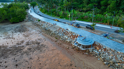 A man sits alone eating in a folding chair on a stone platform, overlooking the rocky intertidal flats, camera at his side, and the peaceful sea in the distance. A quiet moment of solitude at sunset.