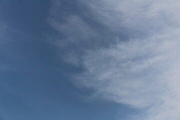 A clear, pale blue daytime sky with wispy, faint clouds scattered across it.
