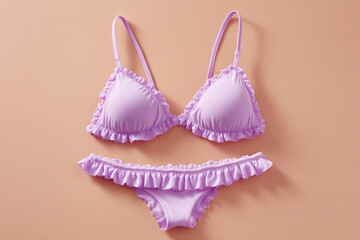 Lilac swimsuit set with ruffled trim against a peach backdrop. Perfect for stylish summer days and poolside relaxation. #swimwear