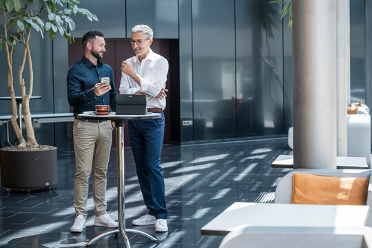 Manager giving advice to team member during business discussion in modern office