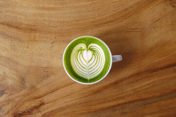 A cup of green tea matcha latte on wooden background                                                                                                                                                    