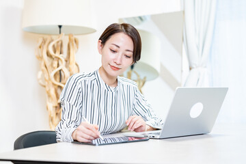 パソコンとタブレットを使い仕事をする女性
