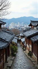 Naklejka premium Cobblestone alleyway in a traditional Asian village with city views.