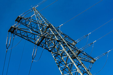 High voltage power line tower against clear blue sky
