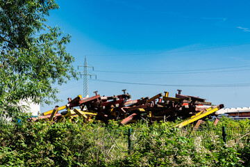 Construction rusted metal debris piled high against clear blue sky