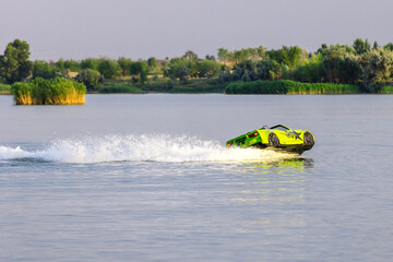 Young man riding a jet ski shaped like a car during summer vacation. Concept of speed, freedom and unique water entertainment.