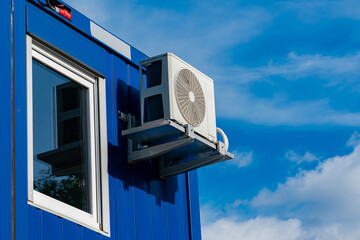Window air conditioning unit mounted on blue building