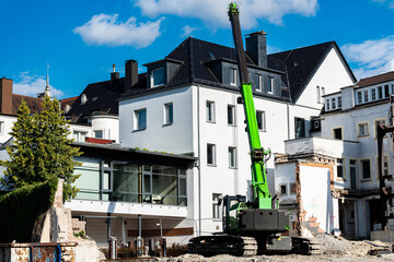 Construction work with a green crane in urban area with debris
