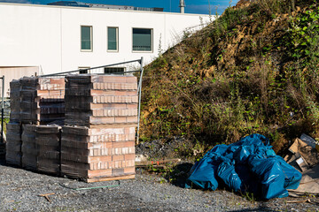 Construction site with stacked materials and waste in the bags.