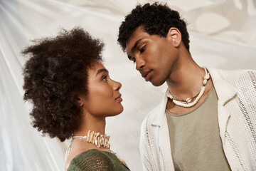 Young couple sharing a tender moment while showcasing their unique style in a cozy setting
