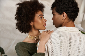 Young couple sharing an intimate moment filled with love and style in a cozy setting