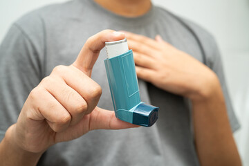 Asthma and chronic obstructive pulmonary disease COPD, Asian young man using metered dose inhaler...