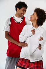 Young couple sharing laughter and joy in stylish outfits during a playful moment together