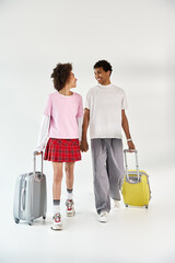 Young couple sharing joyful moments and laughter with their luggage in a stylish setting