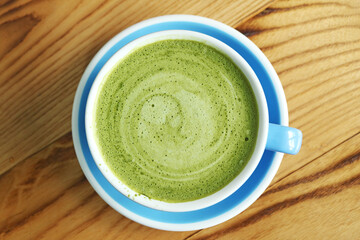 Top View of Hot Matcha Green Tea Latte Isolated on Wooden Background
