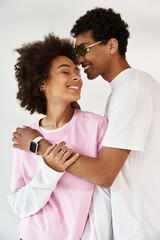 Young couple sharing a joyful moment while embracing in a stylish, modern setting