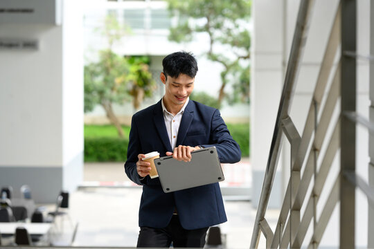 Young businessman smiling while checking time on smartwatch