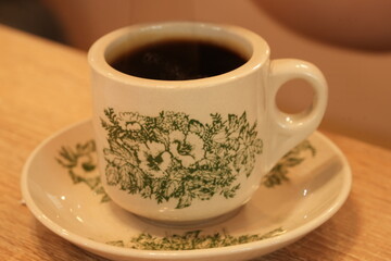 Swirling Cream in Ceramic Coffee Cup with Green Patterns