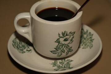 Swirling Cream in Ceramic Coffee Cup with Green Patterns
