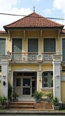 A charming, pastel yellow building with a tiled roof.