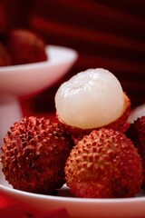 Fresh Juicy Lychees on White Plate with Red background
