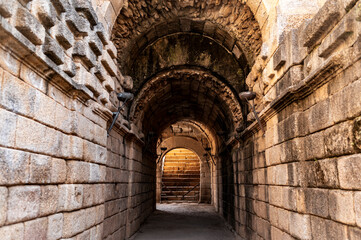 Ancient stone vaulted corridor with textured walls in Roman amphitheater, Merida, Spain