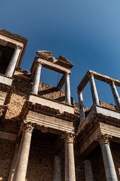 Angled perspective of ancient columns and fractured pediment, Roman theatre, Merida, Spain