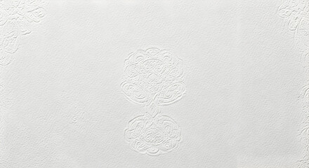 A textured white surface featuring embossed floral designs and intricate corner details