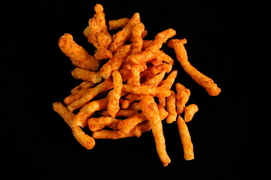 Fresh crunchy puff kurkure sticks on black background 