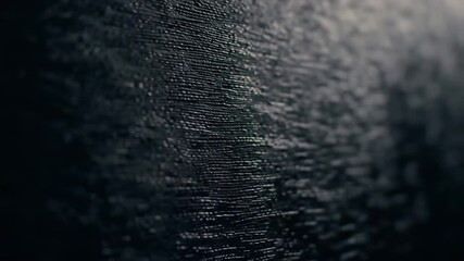 Textured dark surface with many closely aligned horizontal lines fading into dark