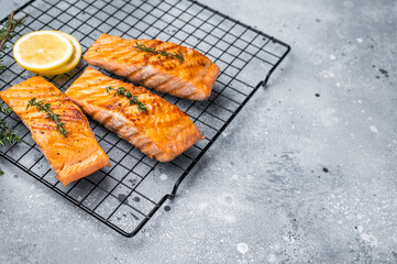 Grilled salmon fillet steak, roast fish on a rack. grey background. top view