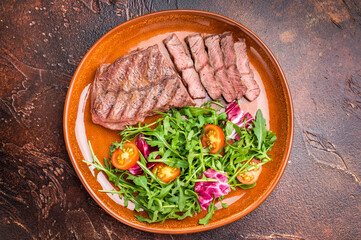 Grilled Australian Oyster Top blade steak with salad on a plate. brown background. top view