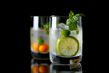Fototapeta premium Refreshing lime and mint cocktail with ice and citrus garnish