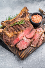 BBQ fried Tomahawk beef steak, grilled marbled rib eye with bone on wooden board. grey background. top view